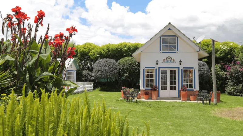 Casa blanca de la sede de Chía rodeada de jardín y flores