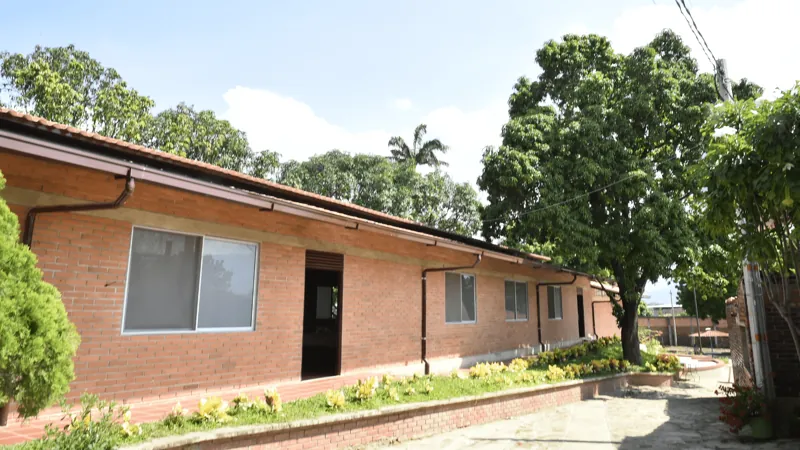 Edificio de ladrillo de un piso rodeado de árboles en la sede de Cúcuta
