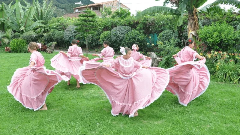 Niñas bailando con faldas rosadas en el prado de la sede de Ibagué