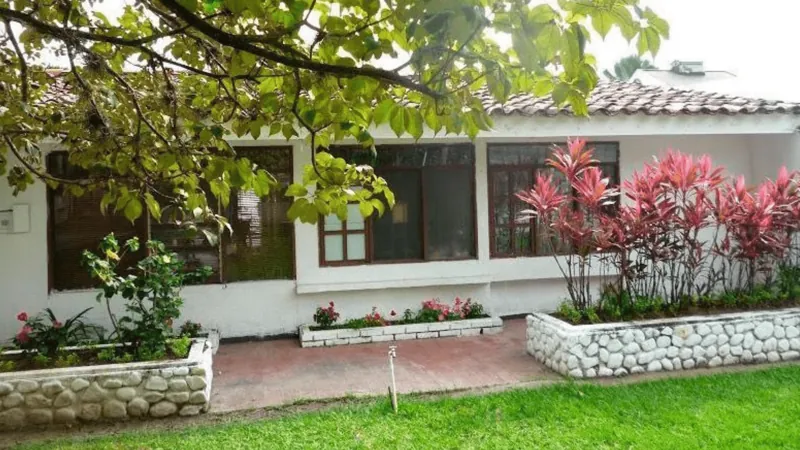 Casa con jardín de flores rojas en la sede de Ibagué