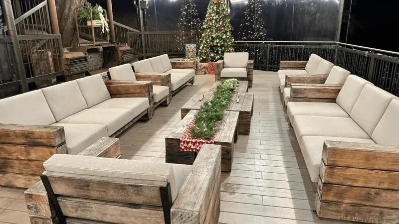 Sala con muebles de madera y cojines blancos en la sede de Medellín