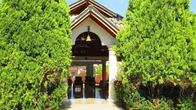Entrada de la sede de Montería entre arbustos